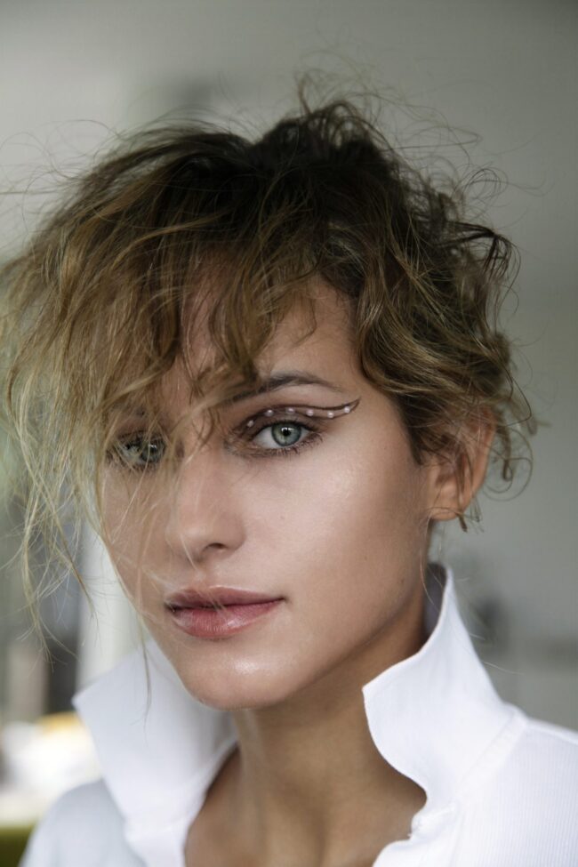 Editorial beauty portrait, tousled natural hair and luminous blue eyes — make-up by Blandine Lagoutte