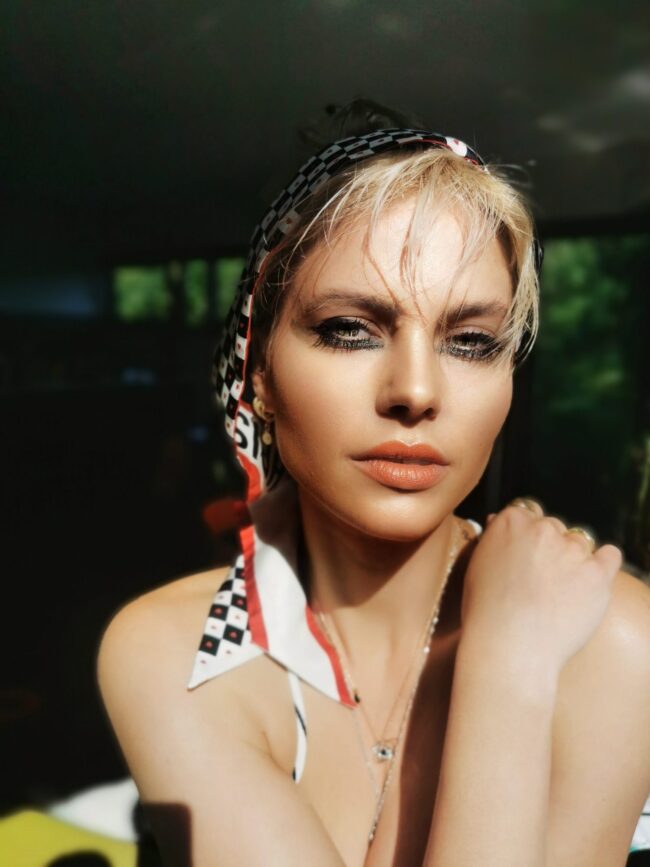 Sunlit editorial look with a printed silk scarf headband, bronzed skin, bold liner — Blandine Lagoutte